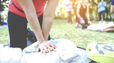 woman performing CPR training on dummy