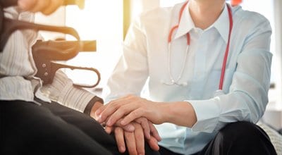 physician talking to patient sitting in walker seat